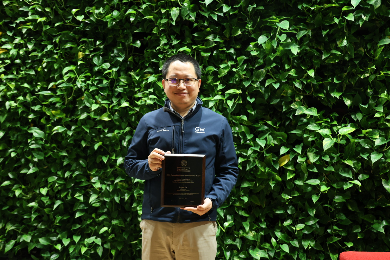 Professor Lu holding his award plaque